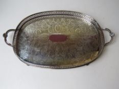 A silver plated serving tray having ball feet and twin end handles with clam shell decoration upon,