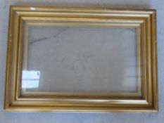 A gilded picture frame with glass and in