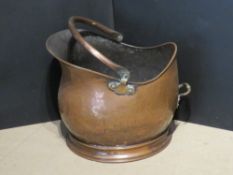 A copper coal scuttle.
