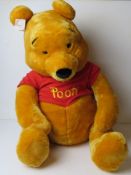 A giant Winnie the Pooh Disney Store cuddly toy, sitting approx 64cm high.