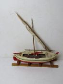 A model of a sailboat with oars, mast a/f, approx 35cm in length.