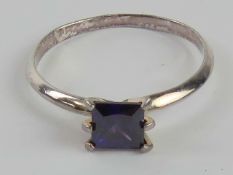 A silver ring having square cut purple s