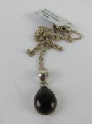 A silver and blue agate pendant on silve