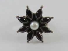 An adjustable silver ring of floral form