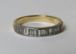 An 18ct gold and diamond half eternity ring having row of baguette cut diamonds set in white metal
