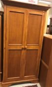 A modern teak two door wardrobe on bracket feet 107.5 cm wide x 62 cm deep x 197.