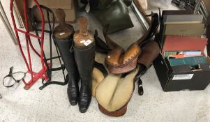 A pair of black hunting boots with wooden trees,