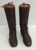 A box containing a pair of brown leather polo boots with wooden trees,