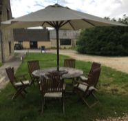 A teak garden table together with a cream canvas covered parasol together with a set of six Royal