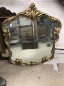 A pair of 20th Century giltwood and gesso framed wall mirrors in the Rococo style with scrolling