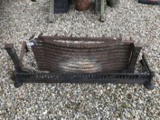 A pair of cast iron fire dogs and cast iron basket together with a part fire kerb