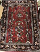 A fine Persian rug, the central panel set with Mirhab design on a red ground,