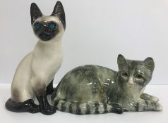 A Winstanley Pottery cat in grey/green tones lying down, signed 