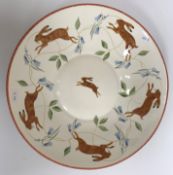 A modern decorative charger painted with running hares, signed to base 