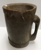 A 19th Century (or possibly earlier) carved treenware measure of mug form,