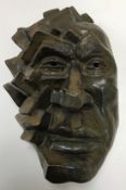 A 20th Century pottery face mask sculpture with relief work block type cubist style decoration and