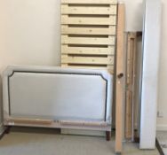 A modern beige upholstered and brass stud decorated king size bedstead with mattress,