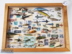 A wall handing display of plugs, Devons and naturalistic lures mounted on a background of stamps