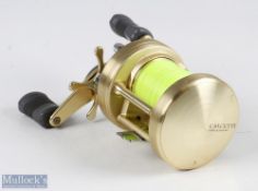 Shimano Calcutta 400s multiplier reel, in gold finish, twin grey handles, runs smooth, with signs of