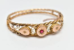 AN EDWARDIAN 9CT GOLD HINGED BANGLE, designed with two textured yellow rope twist bands set apart