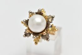 A WHITE AND YELLOW METAL CULTURED PEARL RING, of foliate design, set with a principal part drilled