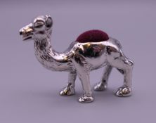 A sterling silver camel form pin cushion. 3 cm high.
