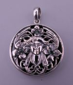 A sterling silver Art Nouveau style pendant. 3 cm diameter.