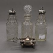 A silver mustard pot, two silver topped cut glass sifters and a cut glass jar.