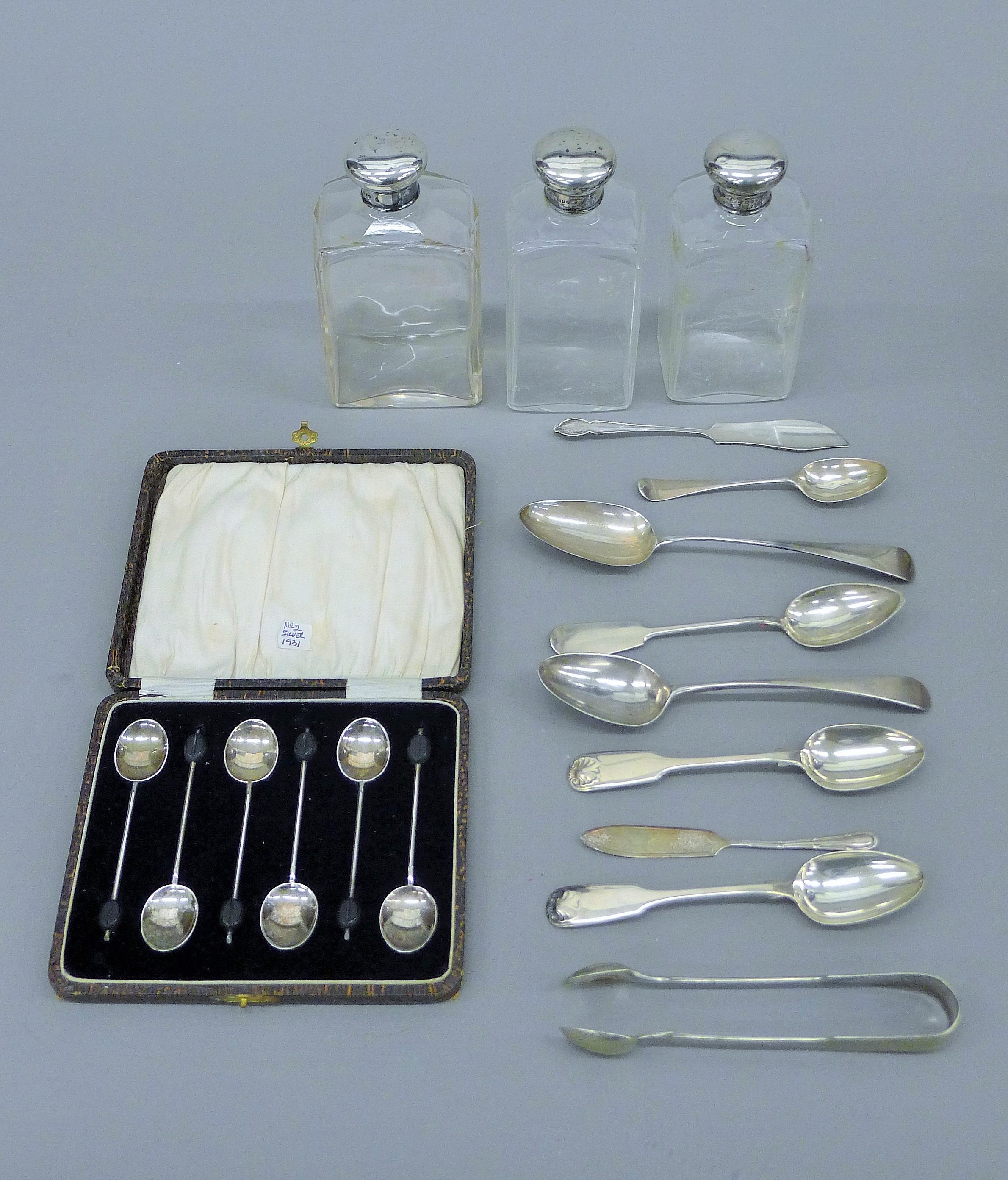 Three silver topped bottles, and various silver and plated spoons, etc.