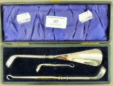 A cased set of button hooks and a shoe horn, the silver handles formed as golf clubs. The box 20.