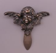 A silver bookmark formed as a cherub's head and wings. 5 cm x 5 cm.