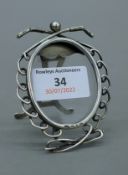 A small silver photograph frame decorated with golf clubs. 8 cm high.