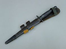 A Sykes-Fairbairn SAS Commando dagger, with etched blade ''Who Dares Wins'', with leather sheath.