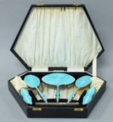 A cased silver and enamel dressing table set. The case 39.5 cm wide.