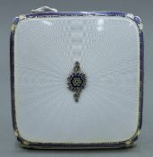 An enamel decorated silver compact. 6.5 cm square.
