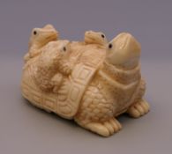 A bone carving formed as frogs and a tortoise. 5 cm long.
