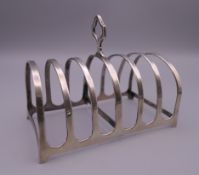 A silver toast rack, hallmarked Adie Brothers Ltd, Birmingham 1923. 11 cm long. 86.3 grammes.