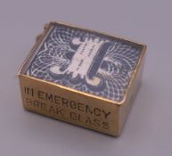 A 9 ct gold charm with enclosed bank note. 1 cm high. 2.7 grammes total weight.