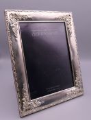 A Carrs silver rectangular silver photograph frame embossed with flowers and foliage. 17 x 22 cm.