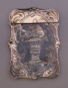 A silver card case. 9 cm high.