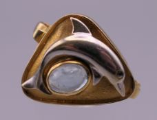 An 18 ct gold aquamarine dolphin form ring. Ring size N. 5.9 grammes total weight.