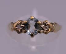 A 9 ct gold three stone diamond and aquamarine ring. Ring size J/K.