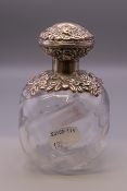A silver topped bulbous perfume bottle. 12 cm high.
