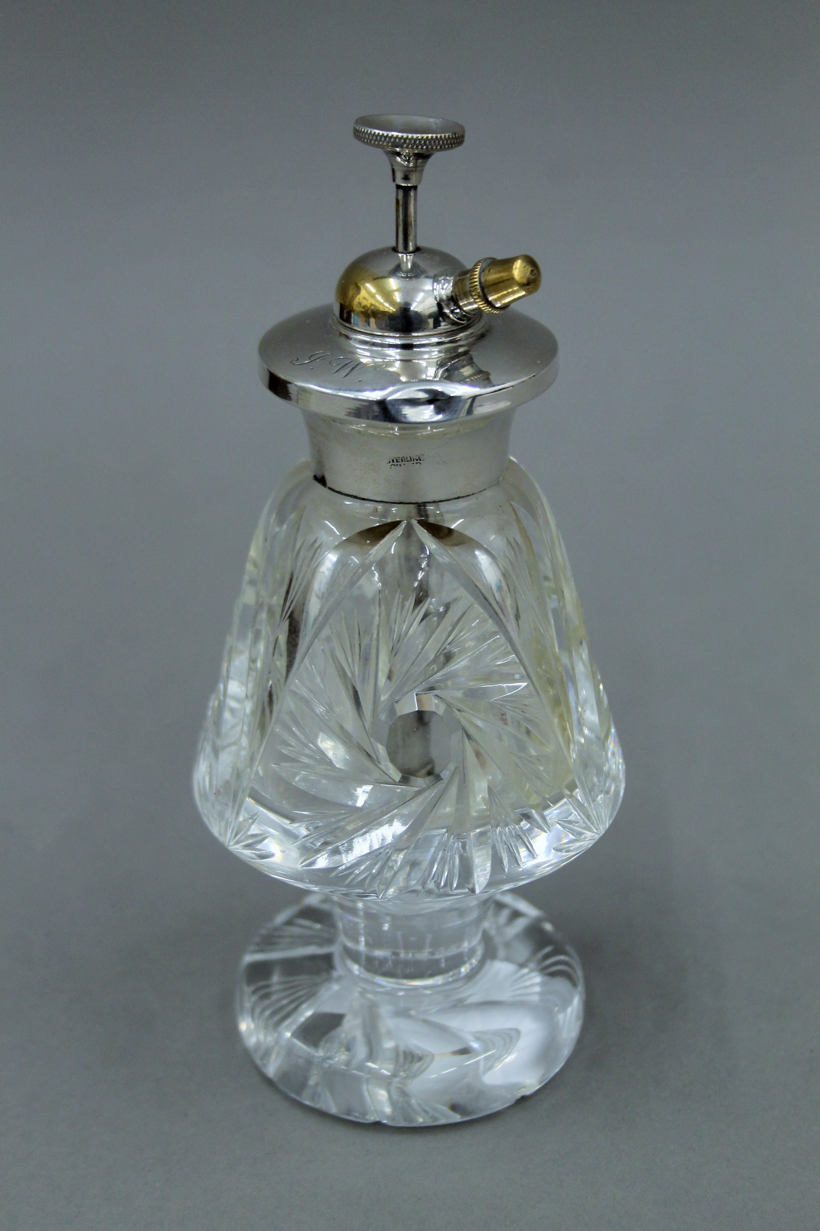 A silver topped cut glass atomiser. 15 cm high.