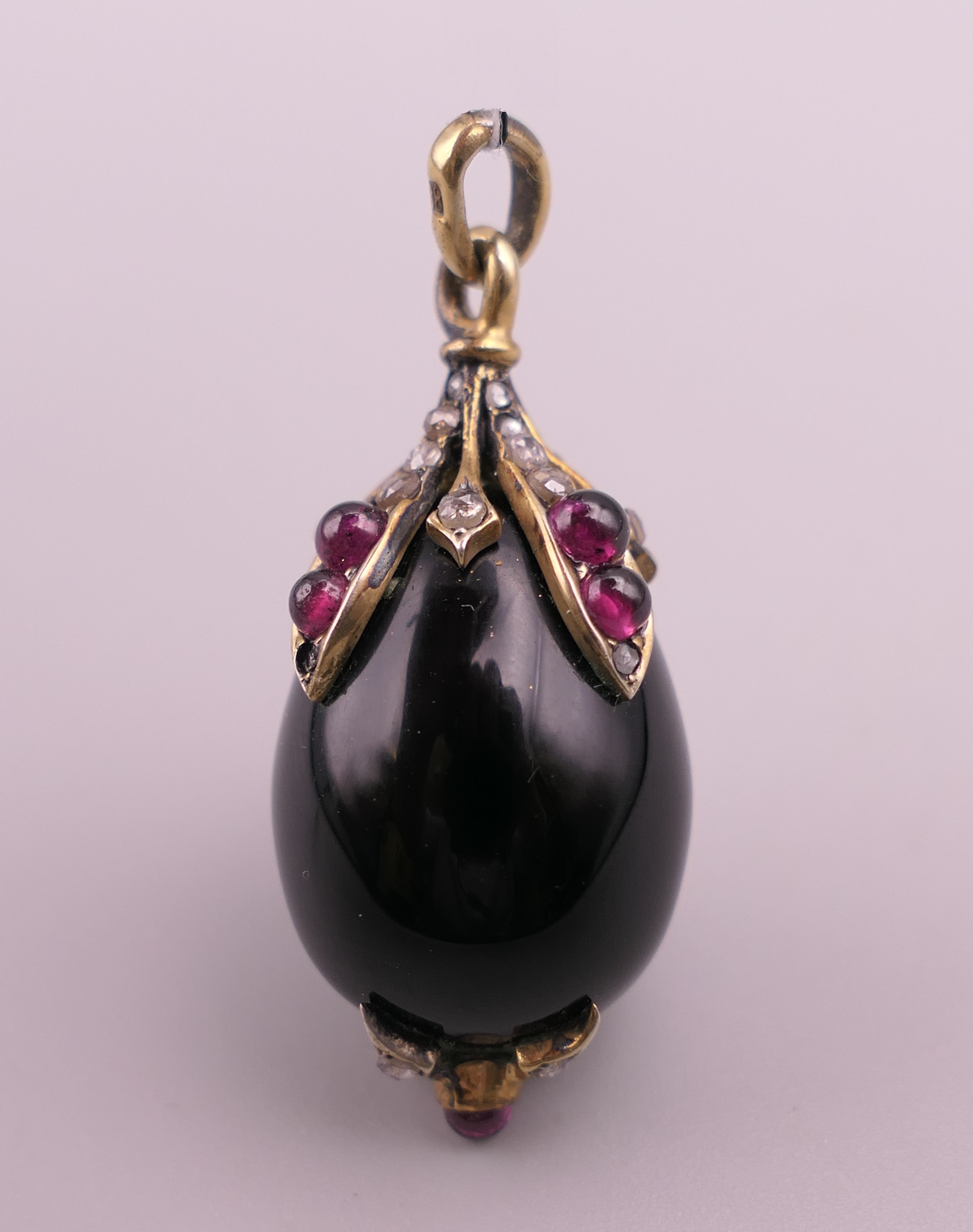A jewelled silver mounted egg form pendant. 3 cm high.