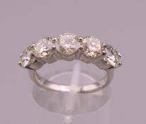 A platinum five stone diamond ring. Approximately 2.65 total carat weight. Ring size M.