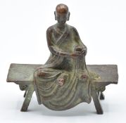 Tibetan 19thC bronze of a Buddhist monk on a bench, 6.8cm tall x 7cm long