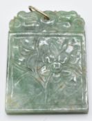A carved jadeite pendant/ plaque depicting flowers, 4.5 x 3.5cm