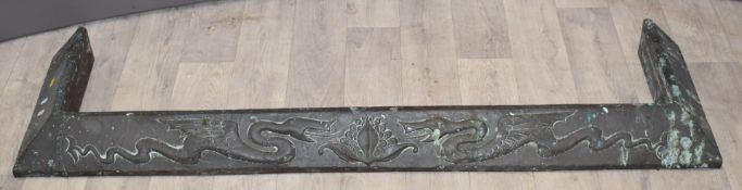 Arts and Crafts copper fire curb decorated with opposing dragons in relief, W119cm