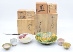 Six pieces of Japanese pottery comprising an Ohi ware bowl, Kashiki bowl and four sake cups, largest